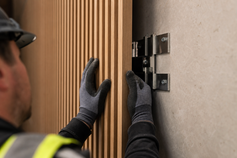 Curated Fabrication installer securing custom millwork panel on-site during professional fabrication installation